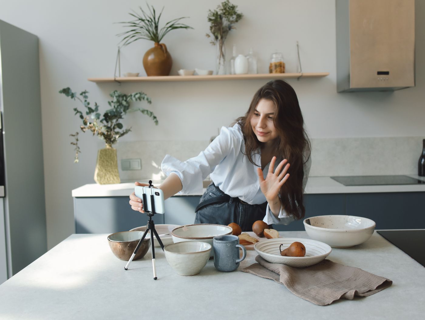Cena ilustrativa: criadora preparando a gravação de um vídeo de rotina com celular e tripé